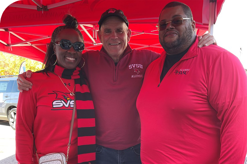 3 alumni smiling at Homecoming